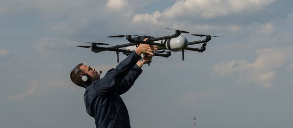 A man prepares to launch an unmanned aerial vehicles (UAV) during UAV demonstration flights. (File) - Sputnik International