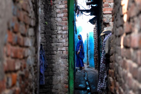 An Indian woman looks on as she stands outside her house in the Kathputli Colony in New Delhi - Sputnik International
