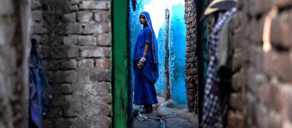 An Indian woman looks on as she stands outside her house in the Kathputli Colony in New Delhi on December 20, 2016 An Indian woman looks on as she stands outside her house in the Kathputli Colony in New Delhi on December 20, 2016 - Sputnik International