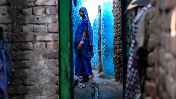 An Indian woman looks on as she stands outside her house in the Kathputli Colony in New Delhi on December 20, 2016 - Sputnik International