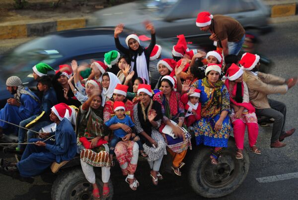 Pakistani revellers, some dressed in 'Santa Claus' hats, take part in a camel rally in Karachi ahead of the celebration of Christmas - Sputnik International