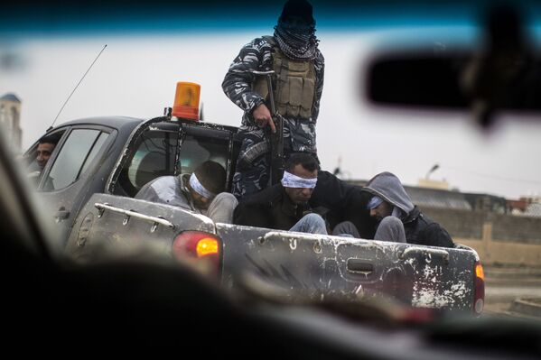 Christian militia fighters from the Nineveh Plain Protection Units (NPU) drive a pick-up truck in Qaraqosh (also known as Hamdaniya), transporting four men, allegedly members of the Islamic State (IS) group that were found inside a tunnel in Mosul - Sputnik International