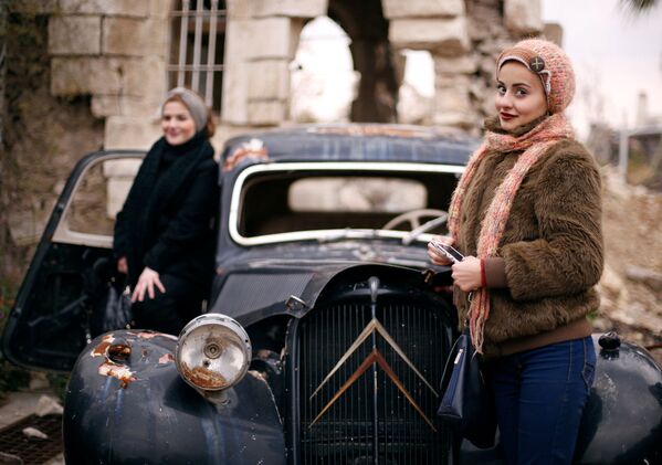 Women pose for a picture at the entrance of the Carlton Hotel, in the government controlled area of Aleppo, Syria - Sputnik International
