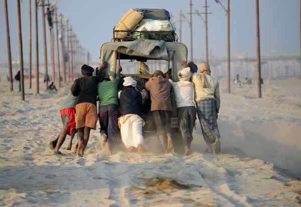 Indian labourers attempt to free a jeep which became trapped in sand on the site of The Magh Mela in Allahabad - Sputnik International