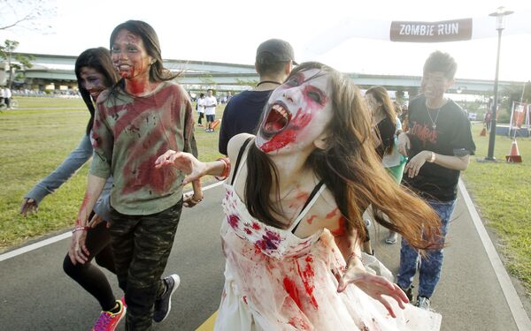 Runners dressed as zombies race during the Zombie Run Taiwan at the Fu Zhou Riverside Park in New Taipei City, Taiwan - Sputnik International