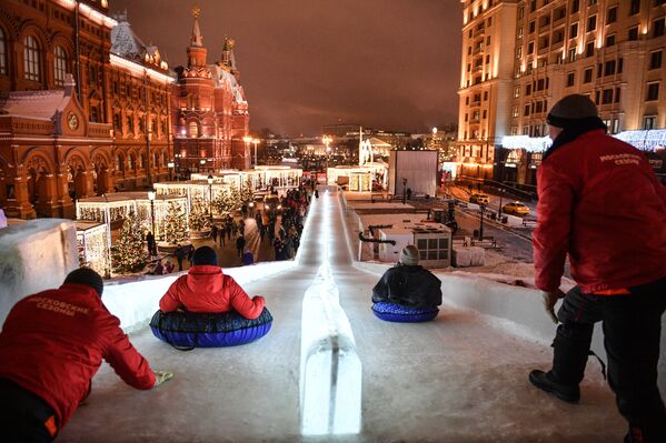 Muscovites on the ice slide in Manezh Square where The Journey to Christmas festival has opened - Sputnik International