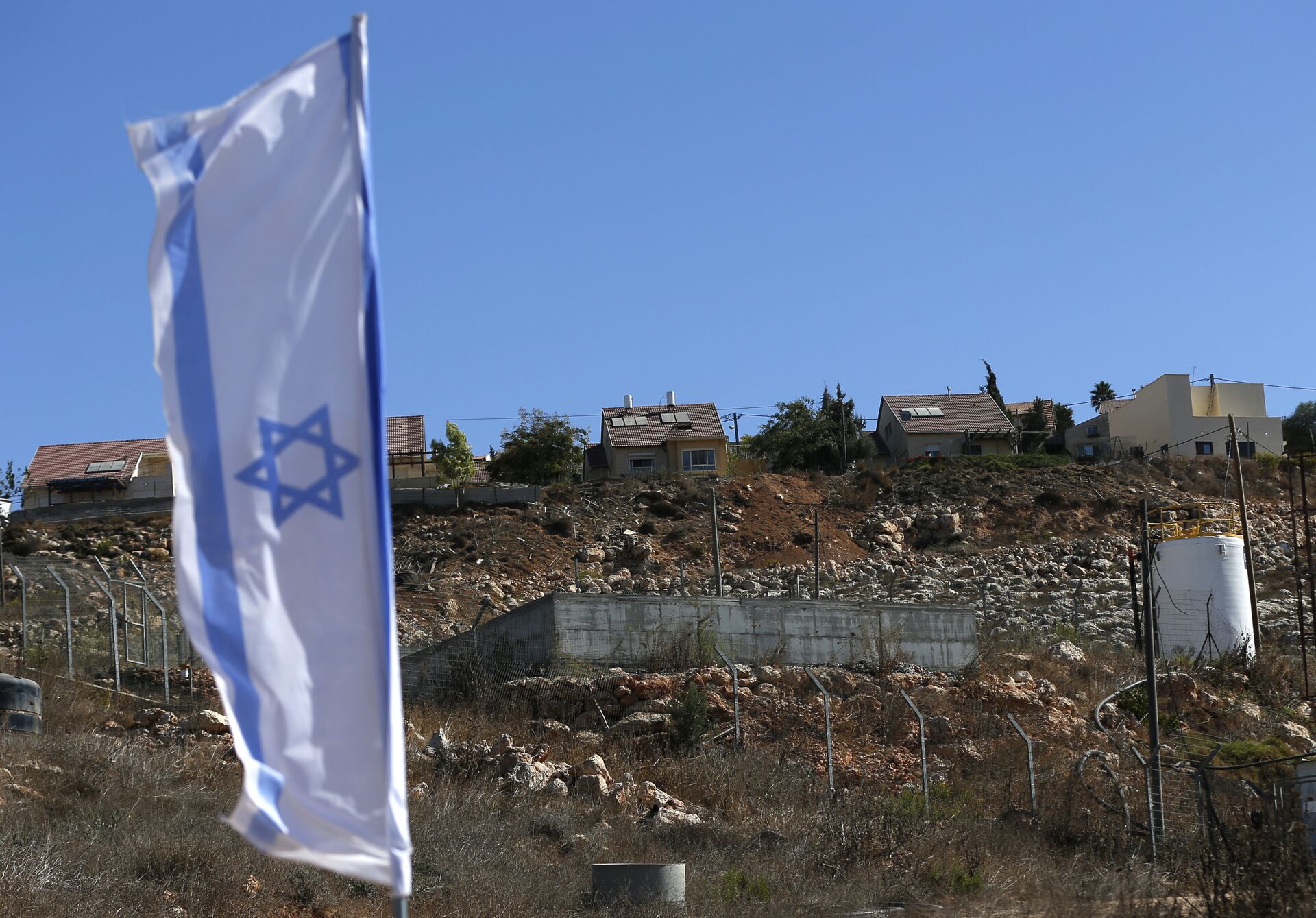 Israeli national flag flying next to an Israeli building site of new housing units in the Jewish settlement of Shilo in the occupied Palestinian West Bank.  - Sputnik International, 1920, 06.06.2022