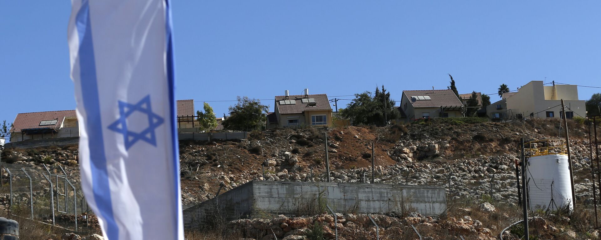 Israeli national flag flying next to an Israeli building site of new housing units in the Jewish settlement of Shilo in the occupied Palestinian West Bank.  - Sputnik International, 1920, 02.12.2021