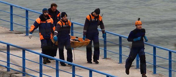 Rescueers carry the body of a victim of Russian Defense Ministry's TU-154 crash on the Black Sea coast off Sochi - Sputnik International