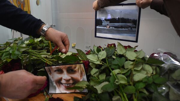 People place a portrait of the founder of Voters' League, charity activist Elizaveta Glinka, known as Dr Liza and a picture of the TU-154 airplane at the airport of the city of Sochi on December 25, 2016, after a Russian military plane which carried dozens of Red Army Choir members crashed. The Russian military - Sputnik International