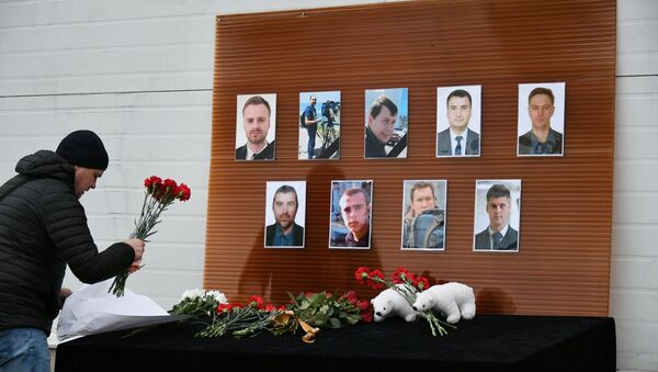 A man outside the Ostankino TV Center lays flowers at the photos of the journalists who died in the Russian Defense Ministry's TU-154 aircraft crash off the Black Sea coast near Sochi - Sputnik International