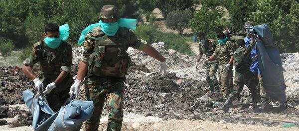 Syrian army troops remove corpses from a mass grave (File) Syrian army troops remove corpses from a mass grave (File) - Sputnik International