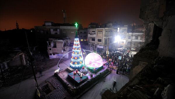 People gather by a Christmas tree near damaged buildings during Christmas eve in al-Hamidiyah neighbourhood in the old city of Homs, Syria December 24, 2016 - Sputnik International