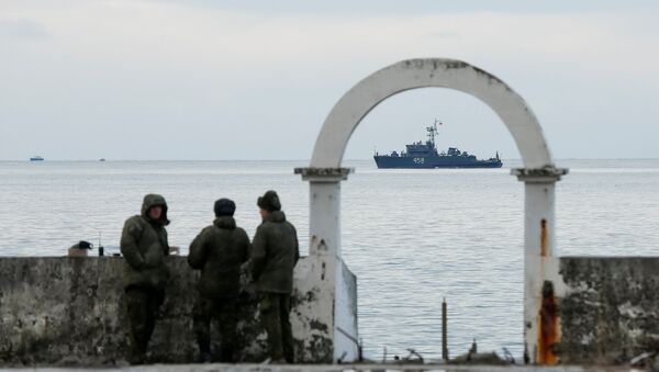 Military personnel watch on a pier as navy ship sails near the crash site of a Russian military Tu-154 plane, which crashed into the Black Sea on its way to Syria on Sunday, in the Black Sea resort city of Sochi, Russia, December 26, 2016 - Sputnik International