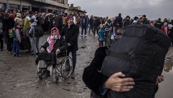 A man in a wheelchair waits to be transferred to a camp for internally displaced people, in Bartella, around 30 km (19 miles), from Mosul, Iraq, Monday, Dec. 26, 2016 - Sputnik International