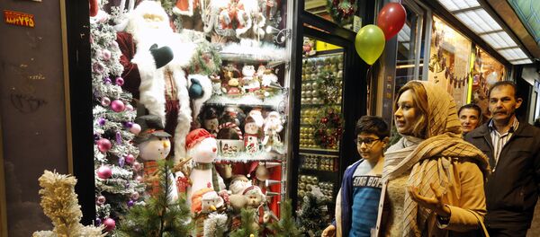 Iranians walk past Christmas decoration at a shop in the capital Tehran on December 24, 2016, on Christmas eve - Sputnik International