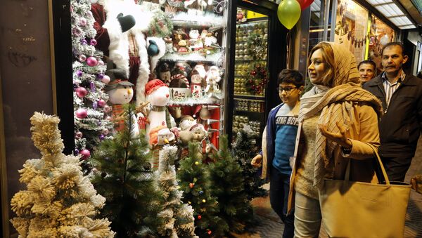 Iranians walk past Christmas decoration at a shop in the capital Tehran on December 24, 2016, on Christmas eve - Sputnik International