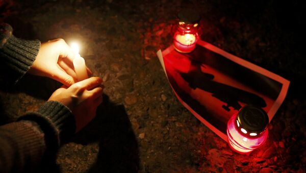 A woman places a candle to honour passengers and crew members of Russian military Tu-154 plane crashed into the Black Sea on its way to Syria on Sunday, at an embankmen in the resort city of Sochi, Russia December 25, 2016 - Sputnik International
