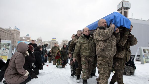 People, including servicemen and civilians, stand and kneel as the Ukrainian soldiers carry the coffin bearing the body of police captain Oleksandr Ilnitsky, who was shot dead by a sniper in the war conflict-hit Donetsk region, during a commemoration ceremony in Independence Square in Kiev, Ukraine, on Monday, Jan. 11, 2016 - Sputnik International