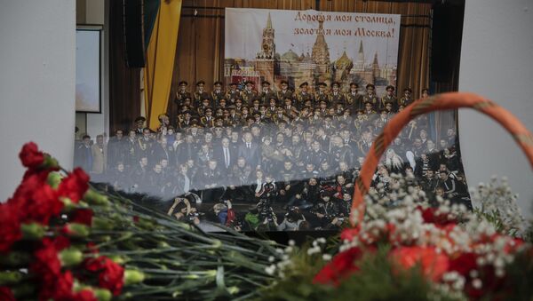 Flowers lay in front of a photo of a well-known military choir lays flowers at the military choir's building in Moscow, Russia, Sunday, Dec. 25, 2016, after a plane carrying 64 members of the Alexandrov Ensemble, crashed into the Black Sea minutes after taking off from the resort city of Sochi - Sputnik International