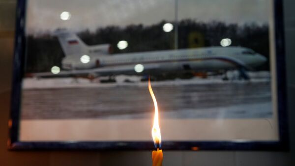 A candle is placed in front of a picture of Tu-154 plane, to commemorate passengers and crew members of Russian military plane, which crashed into the Black Sea on its way to Syria on Sunday, at the Sochi International Airport (Sochi-Adler Airport) in the Black Sea resort city of Sochi, Russia, December 26, 2016 - Sputnik International