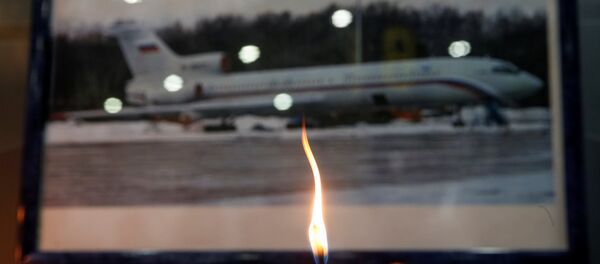 A candle is placed in front of a picture of Tu-154 plane, to commemorate passengers and crew members of Russian military plane, which crashed into the Black Sea on its way to Syria on Sunday, at the Sochi International Airport (Sochi-Adler Airport) in the Black Sea resort city of Sochi, Russia, December 26, 2016 - Sputnik International