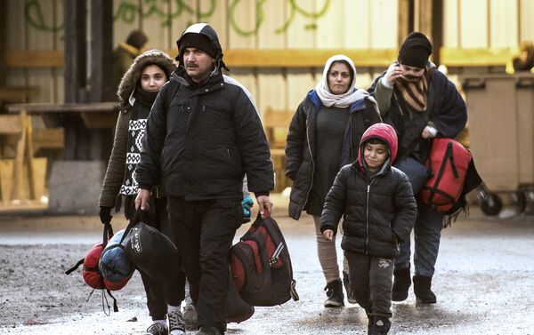 Migrants walk in a refugee camp in Grande-Synthe, northern France. (File) - Sputnik International