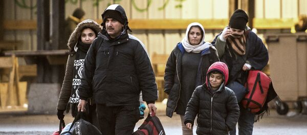 Migrants walk in a refugee camp in Grande-Synthe, northern France. (File) - Sputnik International