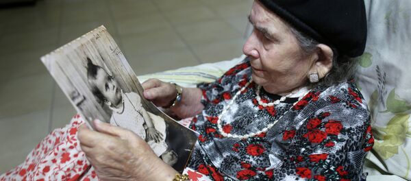 Frecha Amar, 84, from a Moroccan descent, poses with a picture of her baby, who she says was abducted in 1958, on June 29, 2016 at her home in Kfar Chabad, near Tel-Aviv Frecha Amar, 84, from a Moroccan descent, poses with a picture of her baby, who she says was abducted in 1958, on June 29, 2016 at her home in Kfar Chabad, near Tel-Aviv - Sputnik International