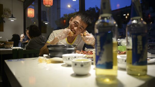 This picture taken on September 8, 2016 shows a man eating a rabbit head at a restaurant in Chengdu, in southwestern China's Sichuan province - Sputnik International