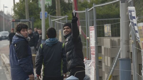 A migrant, who was arrested in Belgium, flashes a victory sign as he crosses the Belgian-French border after being released by the Belgian police at the border on February 26, 2016 in Adinkerke - Sputnik International