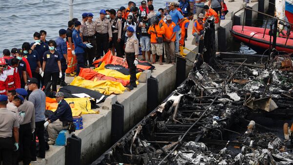 Police, Red Cross and rescue workers prepare to remove body bags containing the remains of victims after a fire ripped through a boat carrying tourists to islands north of the capital, at Muara Angke port in Jakarta, Indonesia January 1, 2017. - Sputnik International