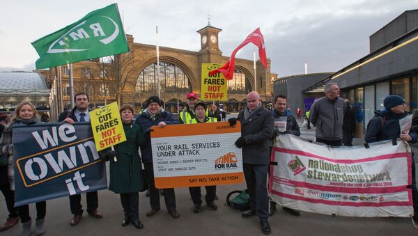 Protestors hold placards as they demostrate against the annual rise in rail tickets, for travel on trains, outside King's Cross railway station in London on January 3, 2017 - Sputnik International