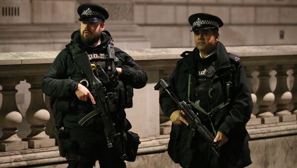 Armed British police officers stand on duty ahead of the New Year's celebrations, in central London. - Sputnik International