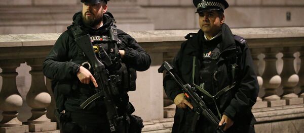 Armed British police officers stand on duty ahead of the New Year's celebrations, in central London. - Sputnik International