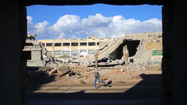 A Syrian boy runs past the rubble of destroyed buildings in the rebel-held area of Daraa, in southern Syria, on January 1, 2017 - Sputnik International