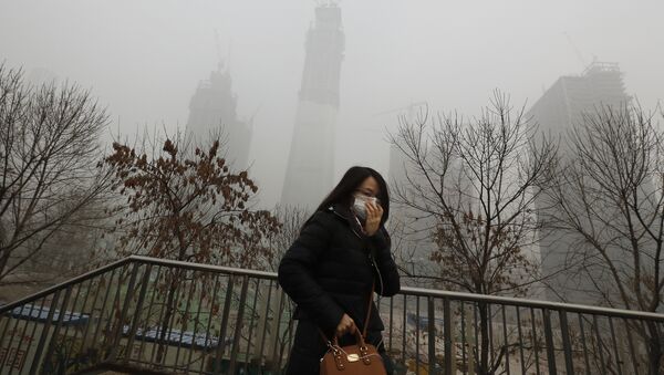 A woman wearing a mask for protection against air pollution walks on a pedestrian overhead bridge in Beijing as the capital of China is shrouded by heavy smog on Tuesday, Dec. 20, 2016 - Sputnik International