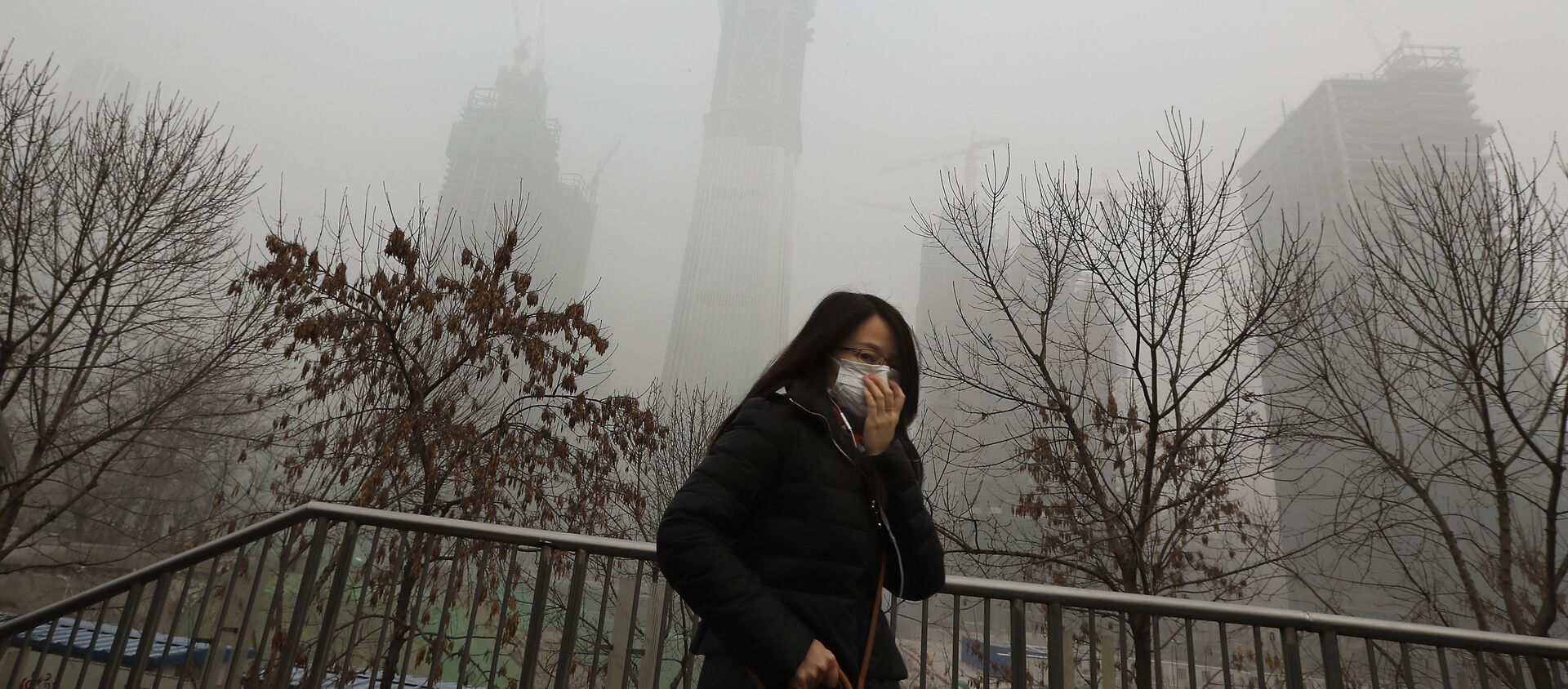 A woman wearing a mask for protection against air pollution walks on a pedestrian overhead bridge in Beijing as the capital of China is shrouded by heavy smog on Tuesday, Dec. 20, 2016 - Sputnik International, 1920, 12.03.2019