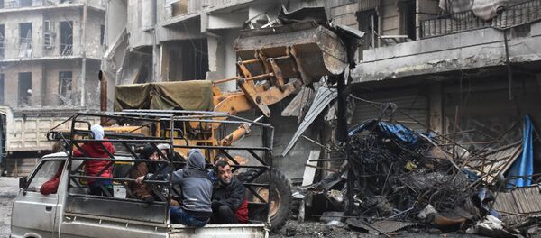Syrian civilians drive past a tractor removing rubble as the Syrian government starts to clean up areas formerly held by opposition forces in the northern city of Aleppo on December 27, 2016, in the Shaar district. Syrian civilians drive past a tractor removing rubble as the Syrian government starts to clean up areas formerly held by opposition forces in the northern city of Aleppo on December 27, 2016, in the Shaar district. - Sputnik International