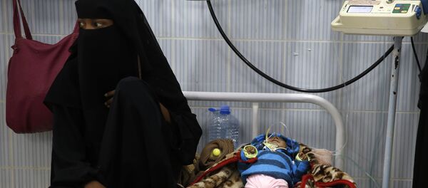 A woman sits next to her malnourished baby at a therapeutic feeding center in a hospital in Sanaa, Yemen. There have been numerous reported cases of dying from starvation in Yemeni hospitals. - Sputnik International
