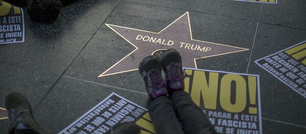 People hold a die-in protest at the Hollywood Walk of Fame star for Donald Trump on Christmas Day in reaction against a Twitter post by US President-elect Trump referring to expansion of the United States nuclear arsenal on December 25 in Los Angeles, California - Sputnik International