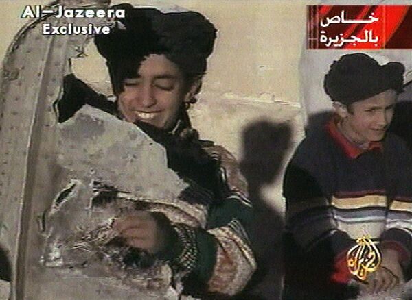 In this image made from video broadcast by the Qatari-based satellite television station Al-Jazeera Wednesday, Nov. 7, 2001, a young boy, left, identified as Hamza bin Laden holds what the Taliban says is a piece of U.S. helicopter wreckage in Ghazni, Afghanistan on Monday, Nov. 5, 2001 - Sputnik International