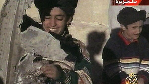 In this image made from video broadcast by the Qatari-based satellite television station Al-Jazeera Wednesday, Nov. 7, 2001, a young boy, left, identified as Hamza bin Laden holds what the Taliban says is a piece of U.S. helicopter wreckage in Ghazni, Afghanistan on Monday, Nov. 5, 2001 - Sputnik International