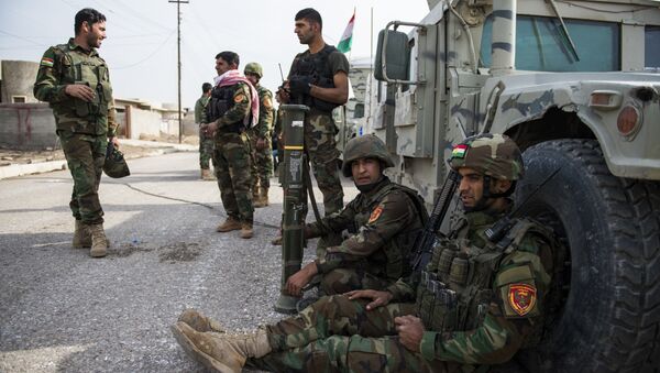 Iraqi Kurdish Peshmerga fighters rest next to their vehicles after returning from combat against Islamic State (IS) group jihadists in Bashiqa on November 9, 2016 - Sputnik International