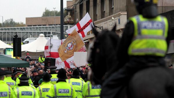 Police officers stand guard as members of the English Defence League (EDL) demonstrate on Bridge Street in Bradford city centre, west Yorkshire, on October 12, 2013. - Sputnik International