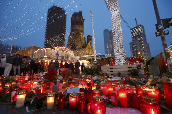 Flowers and candles are placed near the Christmas market at Breitscheid square in Berlin, Germany, December 22, 2016, following an attack by a truck which ploughed through a crowd at the market on Monday night - Sputnik International