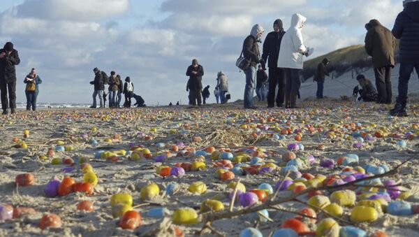 Tourists gather colorful plastic eggs on the beach of the German North Sea island of Langeoog, Thursday Jan. 5, 2017 - Sputnik International
