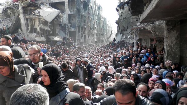 Palestine Refugees in the Near East (UNRWA), residents of the besieged Yarmouk refugee camp near Damascus, Syria, queue to receive food supplies (File) - Sputnik International