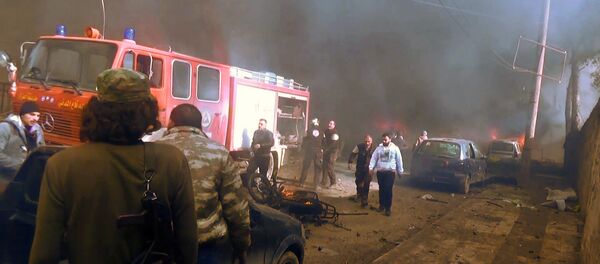 An image grab taken from an AFPTV video released on January 7, 2017 shows people gathering amidst the debris at the site of a car bomb attack in the rebel-held town of Azaz in northern Syria. - Sputnik International