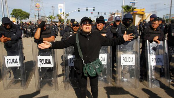 A demonstrator gestures in front of policemen as a group of them blocked the entrance of a Pemex gas storage station during a protest against the rising prices of gasoline enforced by the Mexican government, in Rosarito, Mexico, January 7, 2017. - Sputnik International